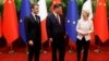 FILE - China's President Xi Jinping, center, his French counterpart Emmanuel Macron, left, and European Commission President Ursula von de Leyen pose for photos as part of a working session in Beijing, China, April 6, 2023.