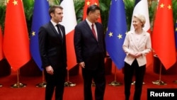 FILE - China's President Xi Jinping, center, his French counterpart Emmanuel Macron, left, and European Commission President Ursula von de Leyen pose for photos as part of a working session in Beijing, China, April 6, 2023.