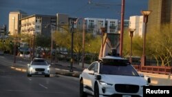 Dua kendaraan swakemudi asal pabrikan Waymo berkendara di Central Avenue di Phoenix, Arizona, pada 18 Maret 2024. (Reuters/Caitlin O'Hara)