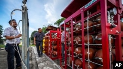 FILE -- P V R Murthy, center, general manager at Oil India Limited, pump station 3, shows a part of a hydrogen plant in Jorhat, India, Thursday, Aug. 17, 2023.