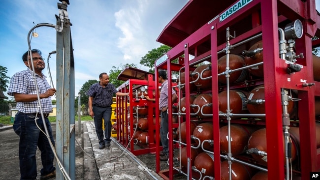 FILE  P V R Murthy, center, general manager at Oil India Limited, pump station 3, shows a part of a hydrogen plant in Jorhat, India, Thursday, Aug. 17, 2023.