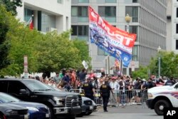 Warga AS berkumpul untuk menyaksikan mantan Presiden Donald Trump (tidak tampak) saat tiba di Gedung Pengadilan Federal AS E. Barrett Prettyman, Kamis, 3 Agustus 2023, di Washington, DC.