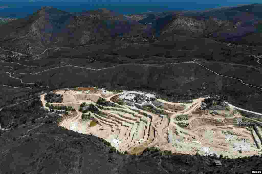 A drone view shows a charred forest area around a marble quarry following a wildfire, in Dionysos, near Athens, Greece.