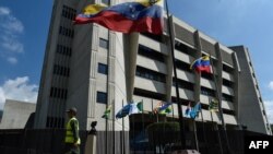 FILE - A member of the National Guard walks past the Supreme Justice Tribunal building in Caracas, Jan. 29, 2019.