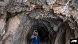 FILE - A Taliban fighter walks at an archaeological site in Mes Aynak, in the eastern province of Logar, May 17, 2022. Mes Aynak — believed to be between 1,000 and 2,000 years old — was once a vast city organized around the extraction and trade of copper.