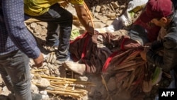 Volunteers recover a body from the rubble of collapsed houses in Tafeghaghte, 60 kilometers (37 miles) southwest of Marrakesh, Sept. 10, 2023, two days after a devastating 6.8-magnitude earthquake struck the country.