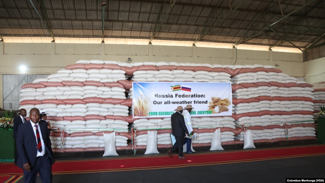 People walk past grain donated by Russia to Zimbabwe, in Harare, March 20, 2024. 