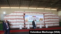 People walk past grain donated by Russia to Zimbabwe, in Harare, March 20, 2024. 