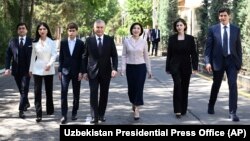 In this photo released by Uzbekistan's Presidential Press Office, Uzbekistan President Shavkat Mirziyoyev, center, and his family leave a polling station in Tashkent, Uzbekistan, April 30, 2023. (Uzbekistan Presidential Press Office via AP)