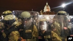 FILE - District of Columbia National Guard stand outside the Capitol, Jan. 6, 2021, after a day of rioting protesters.