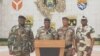Colonel Ulrich Manfoumbi Manfoumbi, 2nd left, transitional government spokesperson, reads a statement on television in this video grab taken from a video obtained by AFPTV from Gabon 24, Sept. 7, 2023. 