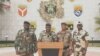 Colonel Ulrich Manfoumbi Manfoumbi, 2nd left, transitional government spokesperson, reads a statement on television in this video grab taken from a video obtained by AFPTV from Gabon 24, Sept. 7, 2023. 