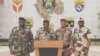 Colonel Ulrich Manfoumbi Manfoumbi, 2nd left, transitional government spokesperson, reads a statement on television in this video grab taken from a video obtained by AFPTV from Gabon 24, Sept. 7, 2023. 