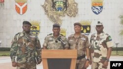 Colonel Ulrich Manfoumbi Manfoumbi, 2nd left, transitional government spokesperson, reads a statement on television in this video grab taken from a video obtained by AFPTV from Gabon 24, Sept. 7, 2023. 