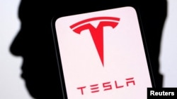 Logo Tesla dan siluet Elon Musk terlihat dalam sebuah ilustrasi, 19 Desember 2022. (Foto: REUTERS/Dado Ruvic)