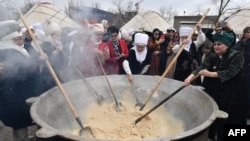People cook the traditional dish &#39;Sumulyk&#39; during the celebrations of Nowruz (New Year) in Bishkek, Kyrgyzstan.