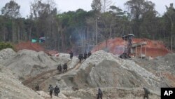 Archivo - La Policía Nacional camina en una operación de minería de oro ilegal donde trabajan para destruir maquinaria como parte de la "Operación Guamuez III" de las Fuerzas Armadas en Magui Payan, Colombia, el martes 20 de abril de 2021.