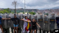 Residents try to block a street to protest the official results declaring President Nicolas Maduro&#39;s reelection, the day after the presidential election as National Guards work to remove them in Caracas, Venezuela.