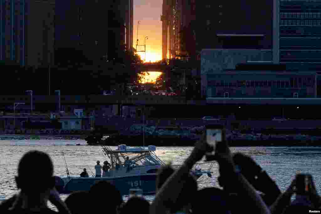 People gather to watch the sunset during a phenomenon known as Manhattanhenge, when the sun lines up with the Manhattan street grid, in Long Island City in the Queens borough of New York City, May 28, 2024. 