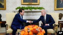 조 바이든(오른쪽) 미국 대통령과 윤석열 한국 대통령이 26일 백악관 오벌오피스(대통령 집무실)에서 회담 직전 악수하고 있다.