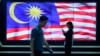 ILUSTRASI - Pejalan kaki berjalan melewati layar yang menampilkan bendera nasional Malaysia di Kuala Lumpur, Senin, 21 November 2022. Khairianwar Jailani, sutradara dan penulis naskah 'Mentega Terbang" dan produser Tan Meng Kheng didakwa meyinggung perasaan keagamaan. 