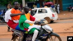 Nigeriens with Russian and Nigerien flags head for an anti-French protest in Niamey, Niger, Aug. 11, 2023.The ECOWAS bloc said it had directed a force to restore constitutional order in Niger after its deadline to reinstate the ousted leader expired.