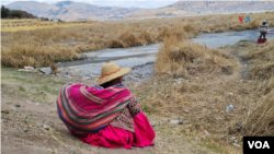 La comerciante aymara Carmen Quispe, de 56 años, observa el canal cada vez más seco a la espera de embarcar hacia la isla flotante de los Uros donde vive.