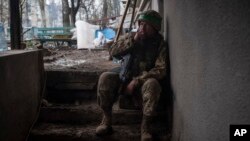 A Ukrainian soldier smokes as he rests in war-hit Bakhmut, Donetsk region, Ukraine, April 12, 2023.