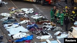 Rescuers and firefighters stand next to the bodies of victims at the scene of a deadly blaze, in Johannesburg, South Africa August 31, 2023.