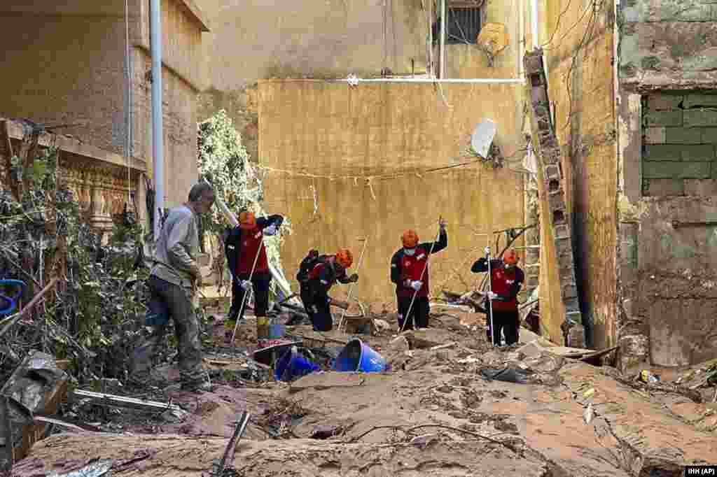 In this photo provided by Turkey's IHH humanitarian aid group, rescuers search for survivors and bodies of flooding victims in Derna, Libya, Sept.13, 2023. 