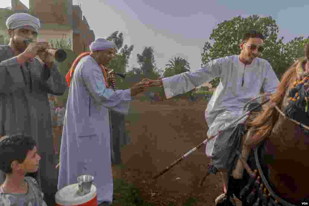 A local band plays festive songs that cheer on each team, naming both human and horse performers in the song for a tip and the performance of an “equestrian dance” in return, Al-Biirat, Egypt on Sept. 12, 2023. (Hamada Elrasam/VOA)