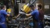 FILE - Technicians work on car assembly lines at the Iran Khodro auto plant, west of the Iranian capital Tehran, Aug. 14, 2022.