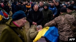 People attend a funeral ceremony for Ukrainian serviceman Yurii Kulyk, 27, killed in Donetsk region, in Kalynivka, near Kyiv, on February 21, 2023, amid the Russian invasion of Ukraine. (Photo by Dimitar DILKOFF / AFP)