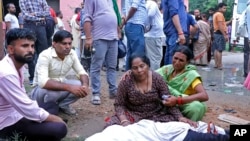 Women mourn next to the body of a relative outside the Sikandrarao hospital in Hathras, Uttar Pradesh state, India, July 2, 2024. At least 60 people are dead and scores are injured after a stampede Tuesday at a religious gathering in Hathras district.