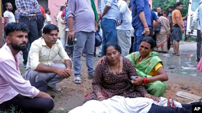 Women mourn next to the body of a relative outside the Sikandrarao hospital in Hathras, Uttar Pradesh state, India, July 2, 2024. At least 60 people are dead and scores are injured after a stampede Tuesday at a religious gathering in Hathras.