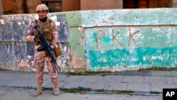 FILE - An Iraqi army soldier stands next to graffiti left by an affiliate of the Kurdistan Workers' Party, or PKK, in Sinjar, Iraq, Dec. 4, 2020. Turkish airstrikes killed 17 members of the outlawed group, the defense ministry said Aug. 12, 2024.