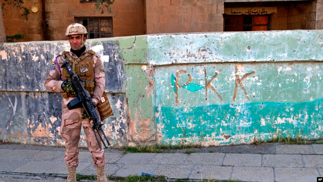 Foto ilustrasi yang menunjukkan seorang tentara Irak berjaga di tembok yang bertuliskan PKK di wilayah Sinjar, Irak, pada 4 Desember 2020. (Foto: AP/Samya Kullab)