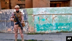 Foto ilustrasi yang menunjukkan seorang tentara Irak berjaga di tembok yang bertuliskan PKK di wilayah Sinjar, Irak, pada 4 Desember 2020. (Foto: AP/Samya Kullab)