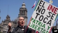 Un manifestante porta un cartel en la plaza del Zócalo de Ciudad de México, el 26 de febrero de 2023, en protesta contra la propuesta del presidente Andrés Manuel López Obrador para reformar el Instituto Nacional Electoral con una reducción drástida de fondos operativos.
