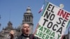 Un manifestante sostiene un cartel durante una marcha contra las recientes reformas impulsadas por el presidente Andrés Manuel López Obrador a la ley electoral del país en la plaza del Zócalo, en Ciudad de México, el 26 de febrero de 2023. 