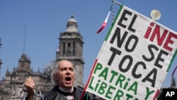 Un manifestante sostiene un cartel durante una marcha contra las recientes reformas impulsadas por el presidente Andrés Manuel López Obrador a la ley electoral del país en la plaza del Zócalo, en Ciudad de México, el 26 de febrero de 2023. 