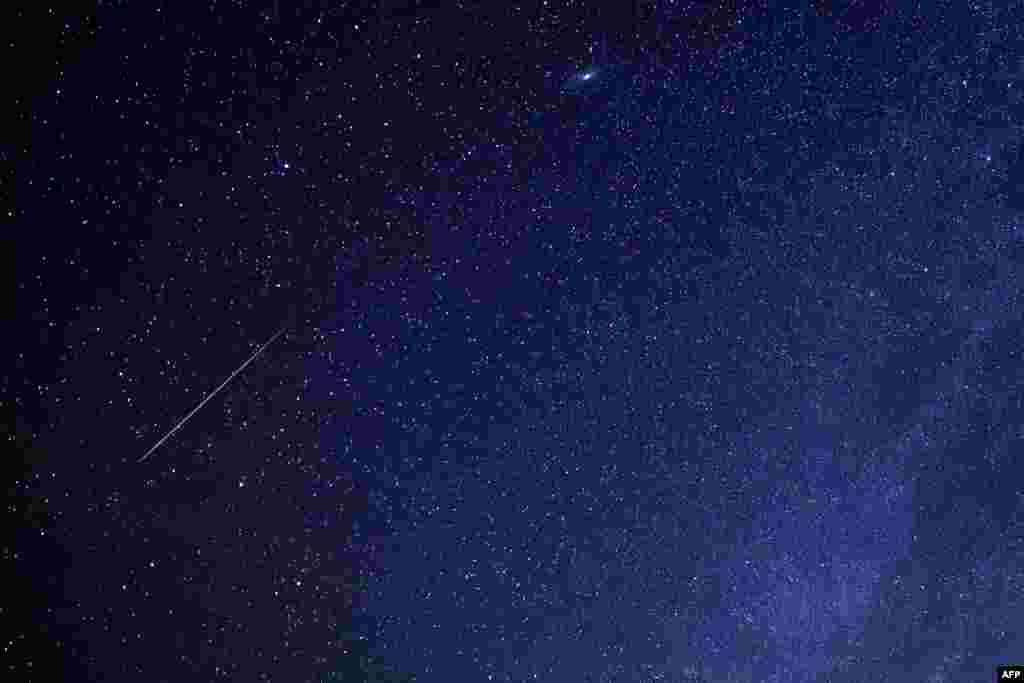 A meteor is seen in the sky over al-Abrak desert north of Kuwait City during the yearly Geminid meteor shower.