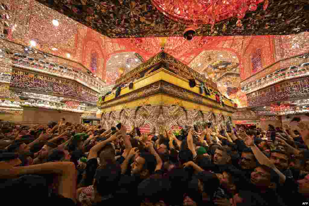 Shiite Muslim devotees reach to receive a blessing from the tomb of Imam Hussein, the Prophet Mohammed&#39;s grandson, at the Imam&#39;s shrine in Iraq&#39;s central holy city of Karbala, during the Arbaeen religious festival. &nbsp;(Photo by Hussein Faleh / AFP)