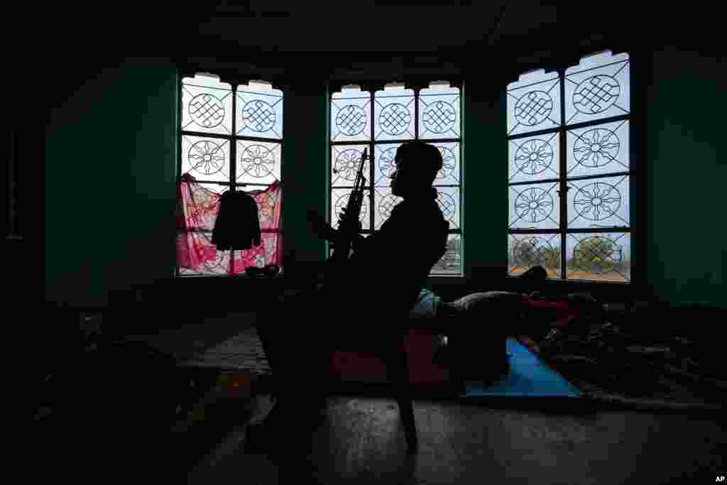 A security person guards a room where electronic voting machines are kept inside a polling station on the eve of general election at Norphung village in Bhutan.