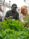 FILE - Bella McGowan, right, works at a community garden with local residents Rico De Rixey, center, and his wife, Geraldine Brand, April 13, 2023, in Los Angeles. 