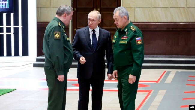 Presidenti Putin duke biseduar me shefin e shtabit Gjeneral Valery Gerasimov (majtas) dhe ministrin e mbrojtjes Sergei Shoigu (djathtas)