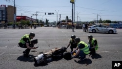 Ukrainian Police officers inspecting a fragment of the rocket after a Russian rocket attack in Kyiv, Ukraine, May 29, 2023.