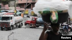 Trucks block the street as residents protest against gangs who control most of the metropolitan area of the capital, in Port-au-Prince, Haiti, April 25, 2023. 