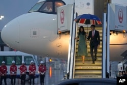 Britain's Prime Minister Rishi Sunak, right, and his wife, Akshata Murty, walk down the steps of an airplane upon their arrival at Hiroshima airport for the G-7 summit, in Hiroshima, Japan, May 18, 2023.