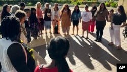 FILE - Supporters of a lawsuit challenging a Hawaii midwife licensure law gather outside a courthouse in Honolulu, June 10, 2024.